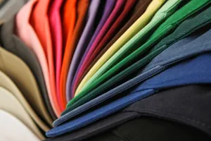 Vista detallada de una pila de gorras de béisbol de colores en lona de sarga