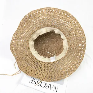 Detail of handwoven crochet paper straw hat featuring sweatband and adjustable drawstring