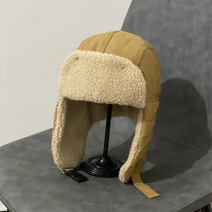 Detail of khaki aviator hat showing warm faux shearling lining and buckle strap