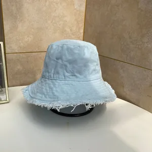 Dettaglio ravvicinato di un cappello pescatore in denim azzurro con bordi sfrangiati