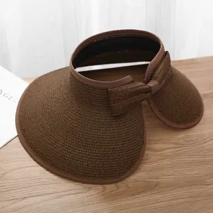 Detail of a dark brown woven sun hat with a large brim and stylish back bow decoration