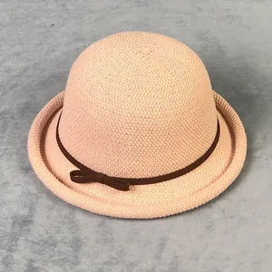 Dettaglio cappello cloche rosa in maglia con tesa arrotolata e fiocco marrone fine