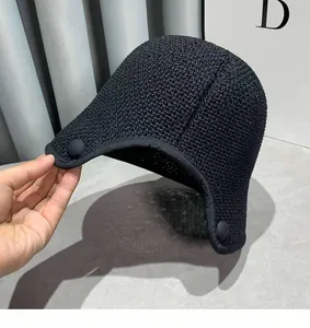 Detailed view of the black knit texture and decorative side button on the beach sun hat