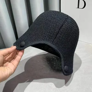Detail of the breathable mesh weave and round snap buttons on this black trapper hat