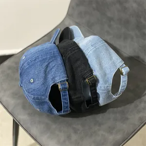 Détail de la boucle en métal réglable sur les casquettes en jean bleu et noir