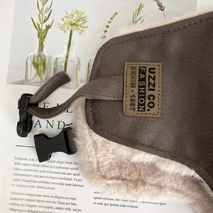Dettaglio del cappello aviatore in pelle scamosciata marrone con fodera in peluche e patch