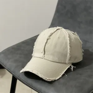 Détail des bords effilochés sur une casquette de baseball vintage blanc cassé
