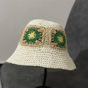 Detail van handgehaakt zonnebloempatroon op een beige zomerse vissershoed van stro