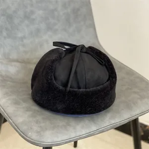 Detail view of black faux suede trapper hat with thick plush earflaps and top ties