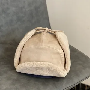Close-up of beige faux suede trapper hat with warm thick sherpa lining and ear flaps
