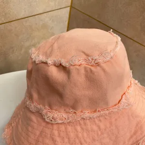 Dettaglio cappello alla pescara rosa in tela con bordi sfrangiati e cuciture a vista