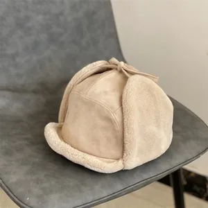 Detail of beige faux suede trapper hat featuring warm lamb wool lining and bow tie top