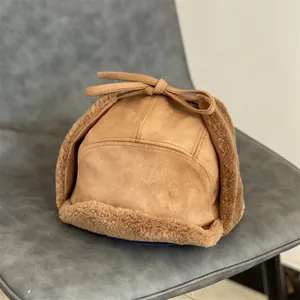 Detailed view of brown suede aviator hat with plush lamb wool lining and chin straps