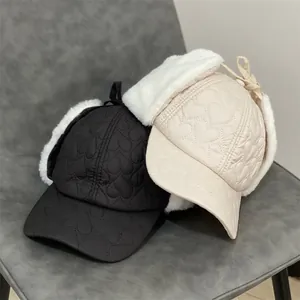 Winter heart quilted trapper hats in black and cream with faux fur lining and ear flaps
