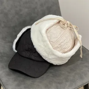 Close-up of heart-quilted thermal bomber hats with faux fur lining and drawstring details