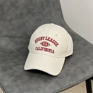Detail of red Rugby League embroidery on a cream cotton vintage baseball cap