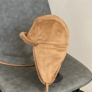 Close-up of brown suede trapper hat with warm white faux shearling lining details