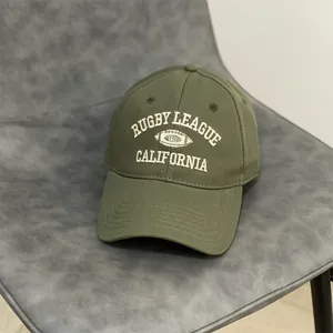 Close-up of olive green cotton baseball cap with retro white rugby league embroidery