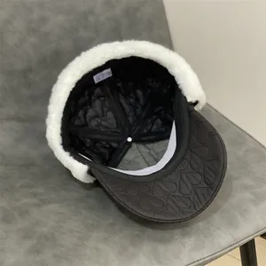 Detail showing heart-shaped quilting and fluffy white faux fur lining on a black winter hat