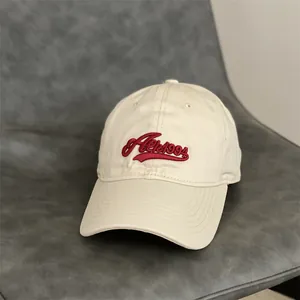 Détail de la broderie 3D rouge et de la texture en coton de cette casquette de baseball beige