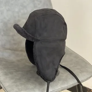 Detail of black faux suede aviator hat with thick faux fur lining on a chair