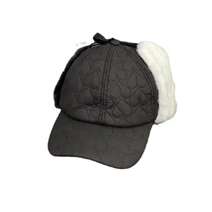 Winter heart-quilted trapper hat with white faux fur earflaps and black ribbon bow