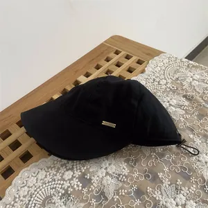 Detail of wool bucket hat with gold Dar Najd metal logo and adjustable elastic cord