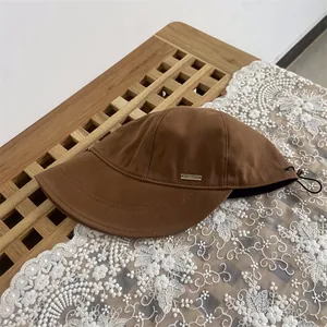 Brown wool felt bucket hat with a vintage metal logo and adjustable drawstring cord