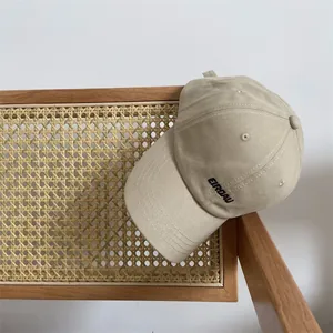 Detailansicht der schwarzen ETROAU-Stickerei auf einer hellbeige Baumwollkappe