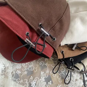 Detail of colorful woolen bucket hats featuring adjustable drawstring with silver metal buckles