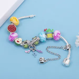 DIY charm bracelet featuring colorful glass beads and musical note pendants on silver chain