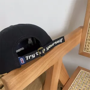 Detailansicht der schwarzen Baseballkappe mit 'Try to be yourself' besticktem Riemen