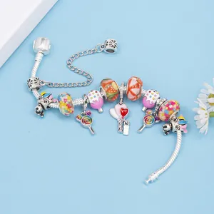 Silver charm bracelet with colorful glass beads and enamel candy pendants on blue backdrop