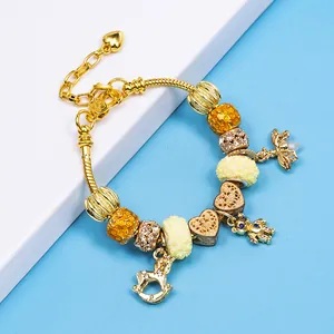 Golden snake chain bracelet with yellow honeycomb beads, rocking horse and bee charms