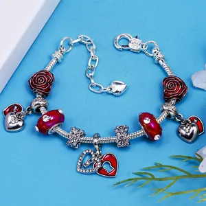 Bracciale argento con charm rose rosse, ciondoli a cuore e cristalli su fondo blu