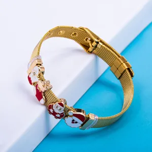 Detail of golden mesh bracelet with Santa Claus and snowflake enamel charms for Christmas