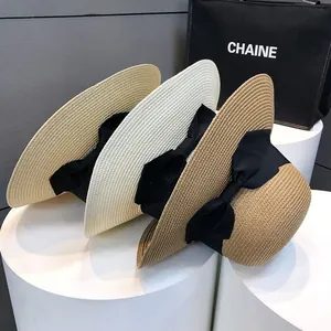 Gros plan détaillé de chapeaux de paille tressés avec nœuds noirs en trois couleurs