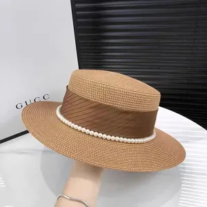 Elegant wide brim straw boater hat with brown ribbon and pearl accents for sun protection
