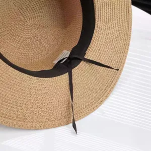 Close-up of woven straw hat featuring black inner sweatband and adjustable drawstring