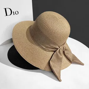 Close-up of elegant woven straw sun hats with wide brims and decorative fabric bows