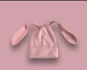 Trama dettagliata del berretto in maglia rosa con lunghe orecchie e risvolto morbido