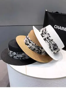 Drei flache Strohhüte in Schwarz, Weiß und Beige mit Blumenband für den Sonnenschutz