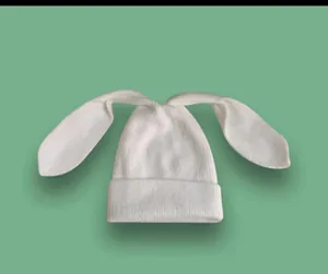 Dettaglio del berretto bianco in maglia con orecchie da coniglio e trama a coste