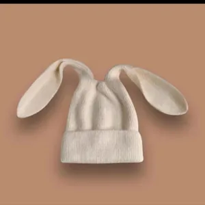 Berretto in maglia crema con lunghe orecchie da coniglio, morbida trama per l'inverno