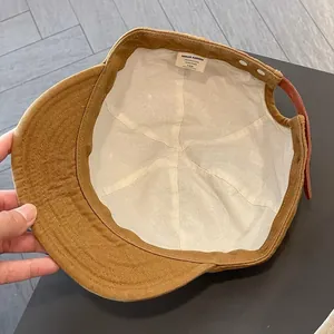 Inside view of brown cotton short brim baseball cap with adjustable leather strap