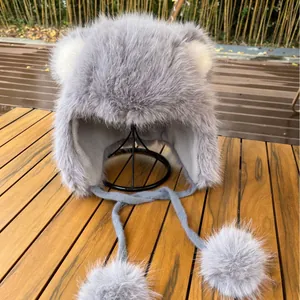 Cappello invernale in peluche con orecchie e pompon su un supporto di metallo