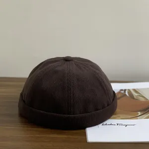Bonnet docker en velours côtelé marron foncé vintage pour hommes et femmes sur bois