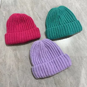 Close-up of ribbed knit rabbit fur hats in magenta, turquoise, and lavender shades