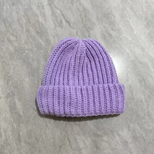 Close-up of thick lavender knit beanie featuring warm ribbed texture and folded cuff