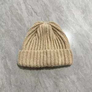 Detailed close-up of thick beige cable knit beanie showing warm fluffy wool texture